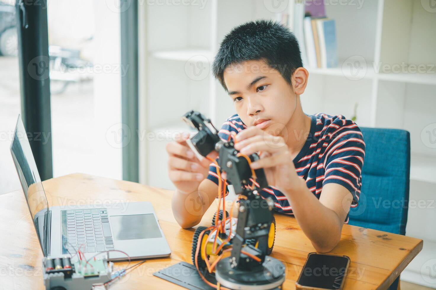 Asian boy learning and studying the work of technology robots.homeschool and science for tech project. playing childhood kids hobby leisure lifestyle people toys robotics technology. photo