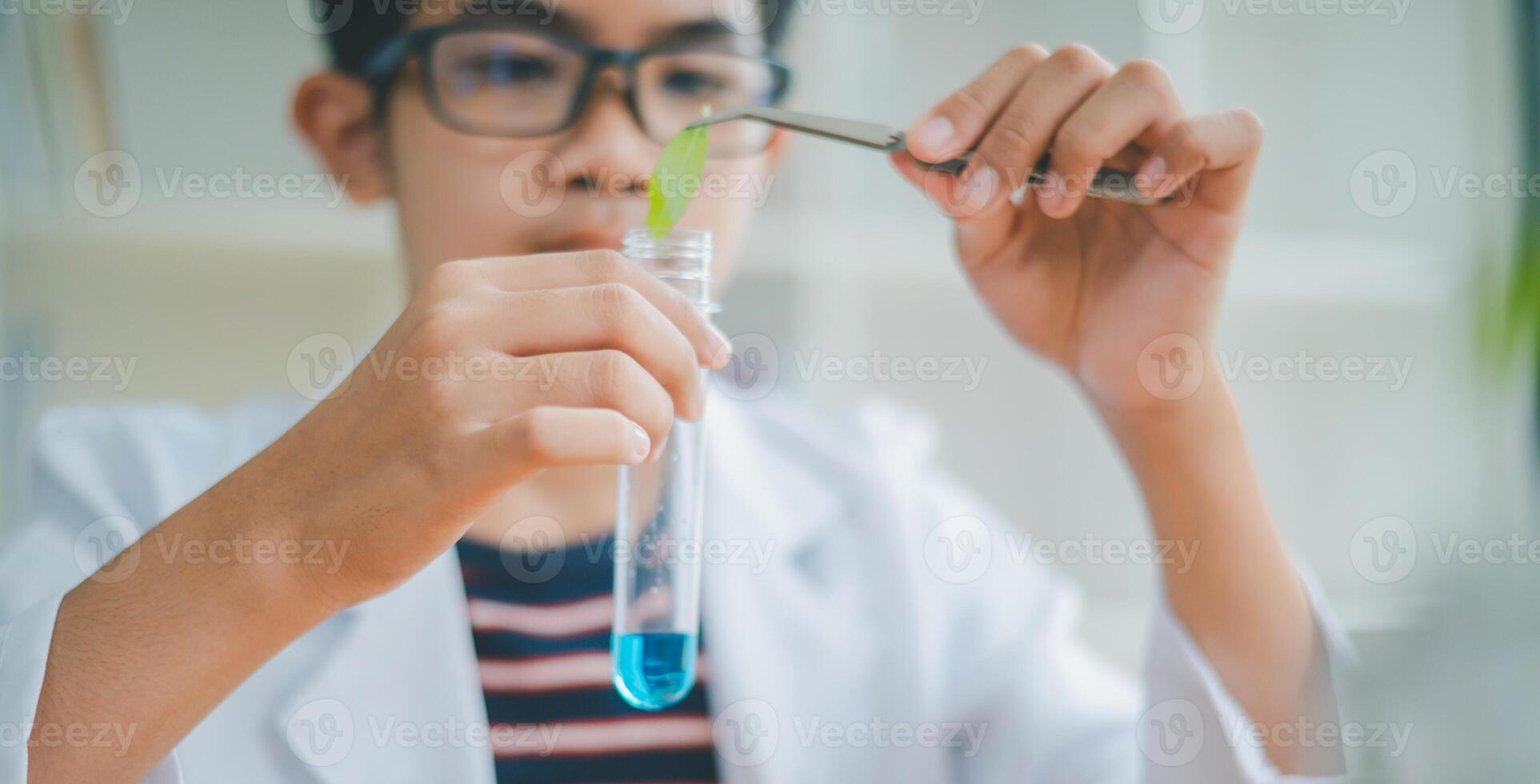 Asian male science students looking through a microscope and tests of plants in the classroom. Learning about scientific experiments on plant species. photo