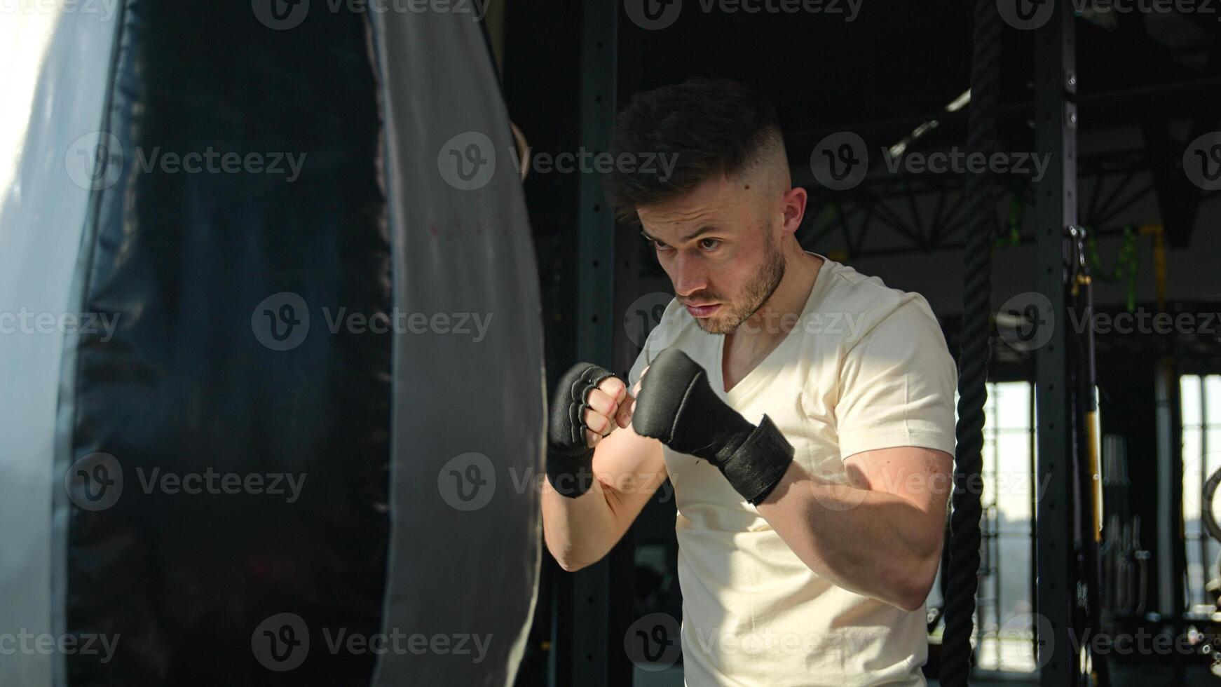 Male sportsman Caucasian man boxer training with punching bag boxing