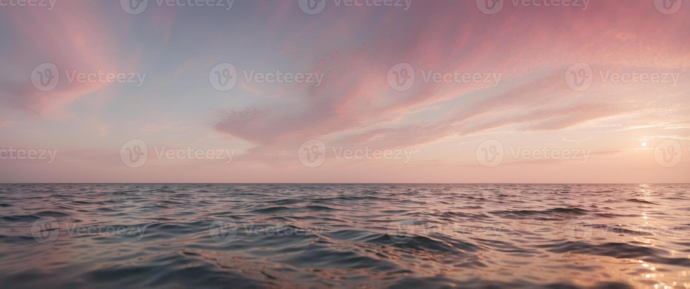 The ocean is calm and the sky is a beautiful shade of pink. photo