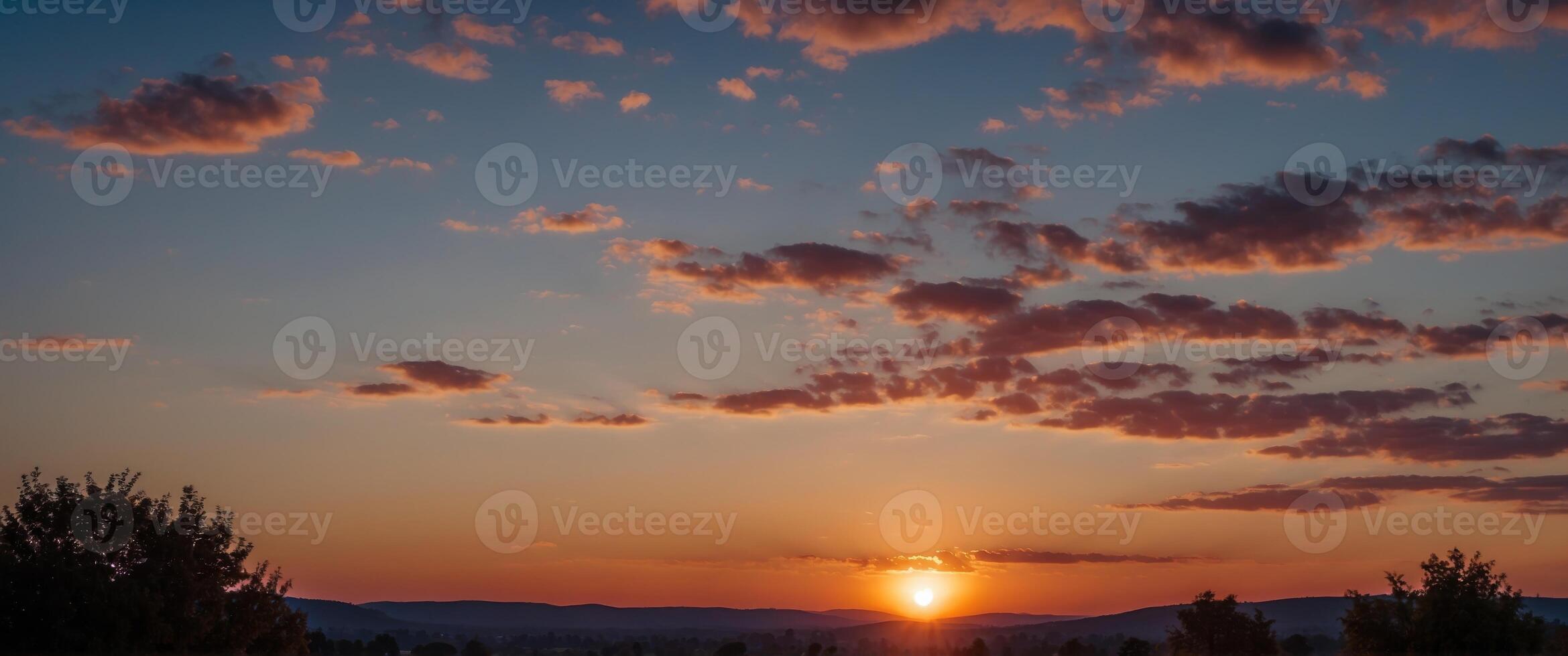 A bright blue and purple sky with a bright red sun. photo