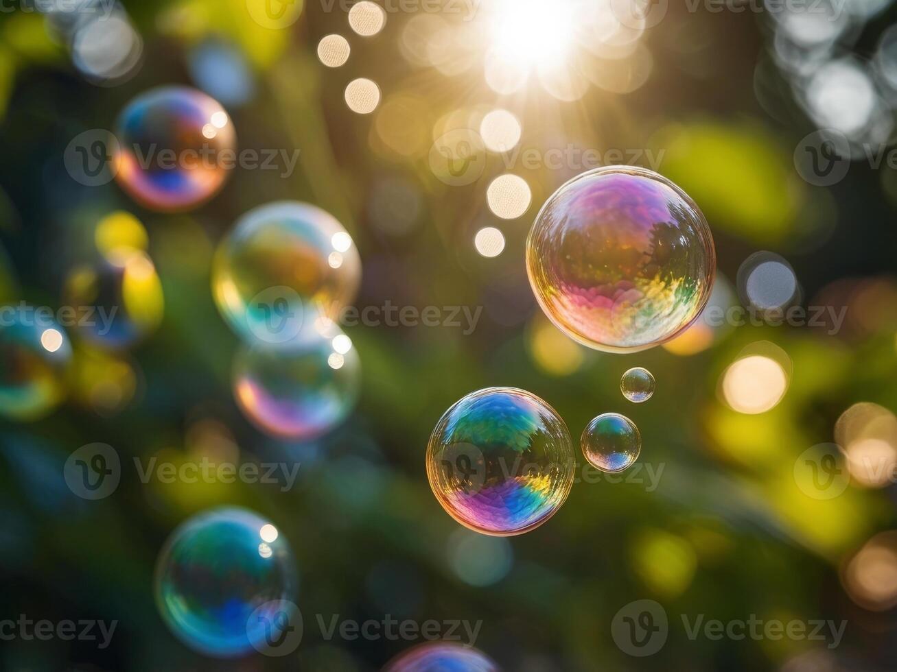 Colorful soap bubbles floating in sunlight through green foliage. photo