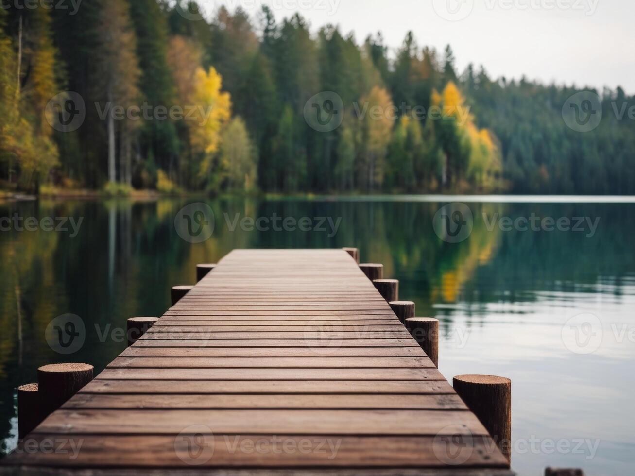 a dock sitting on top of a lake next to a forest. photo