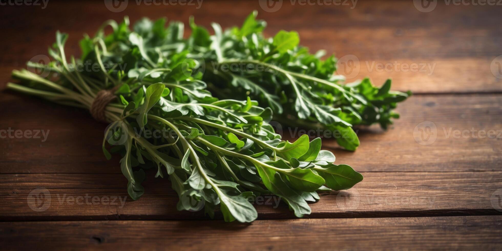 Two Bunches of Arugula on Brown Wooden Background. photo