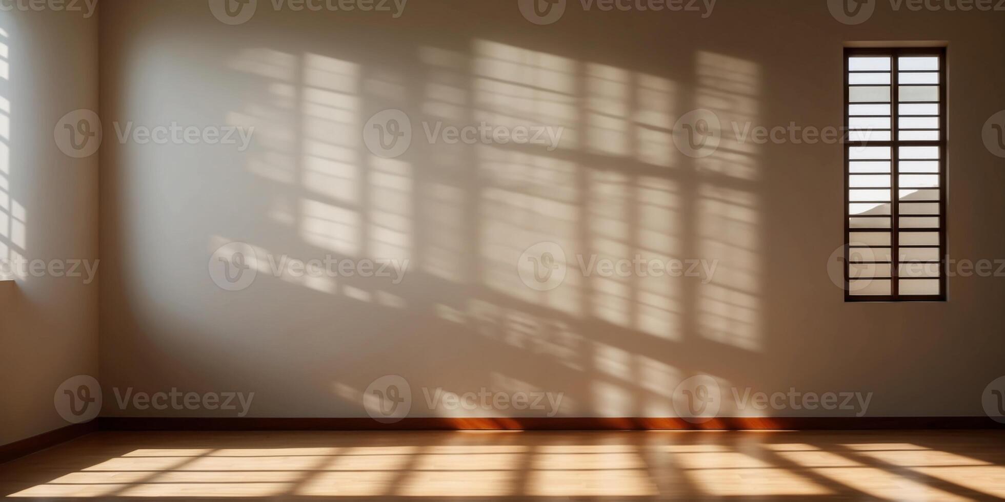 Sunlight is casting geometric shadows from a large window onto the floor of an empty room. photo