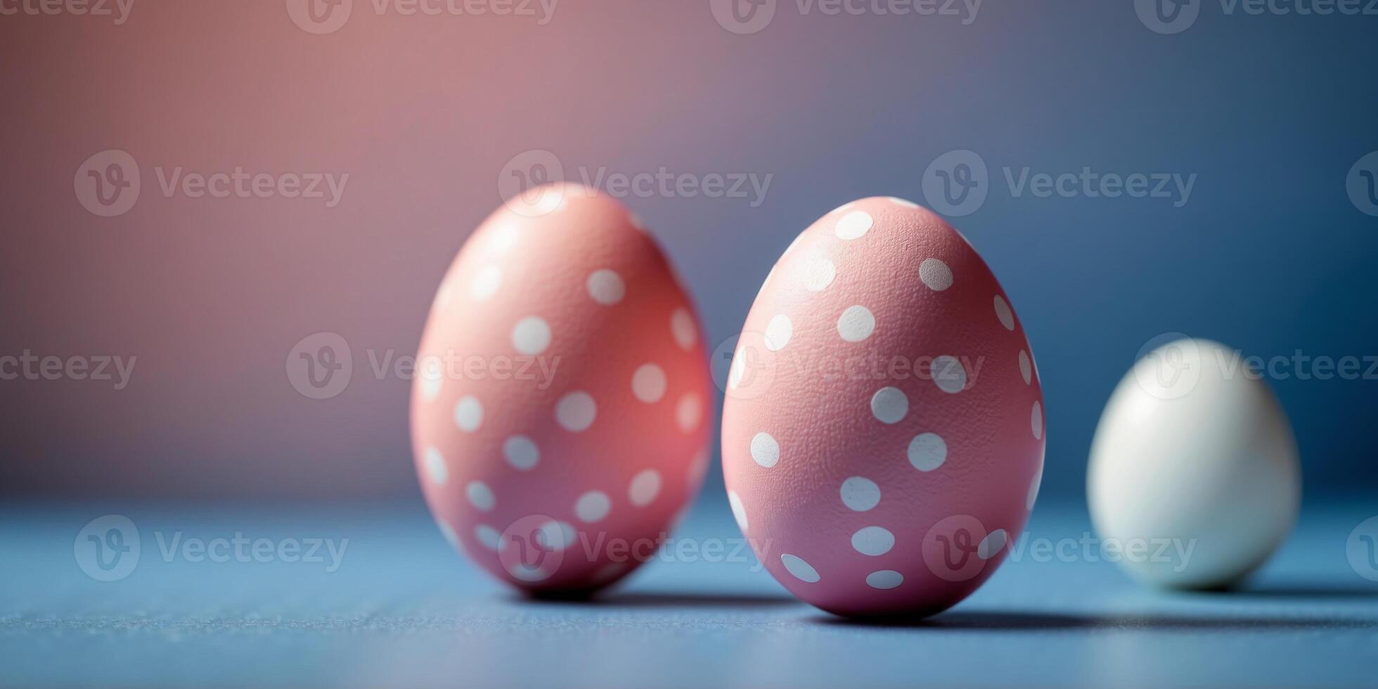 A pink and white egg with polka dots sits on a blue background. photo