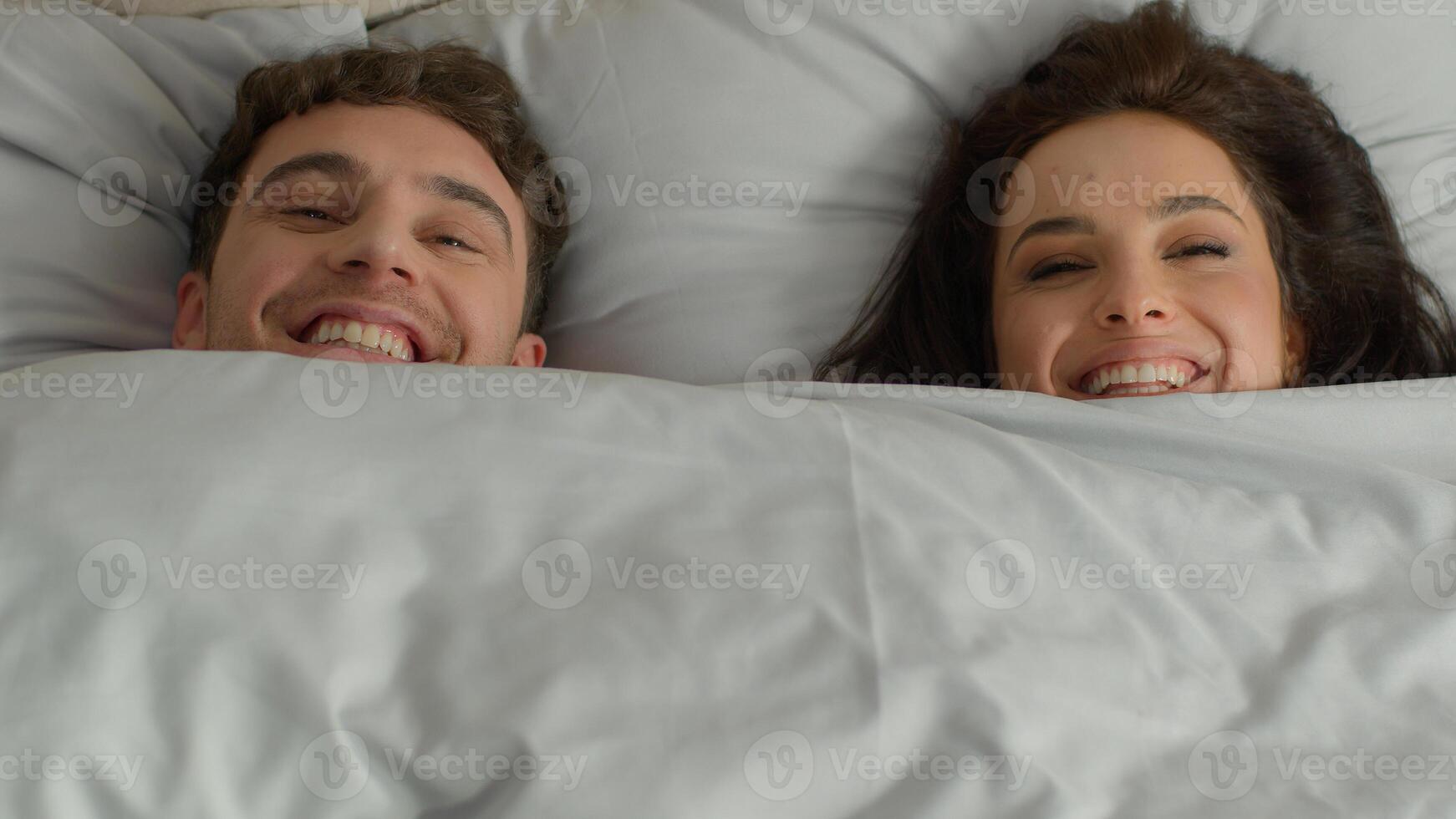 Happy cheerful couple man woman fun joy together duvet female male lying bed bedroom weekend enjoy rest cozy daydream relaxing orthopedic mattress lazy satisfied pleasure carefree girlfriend boyfriend photo