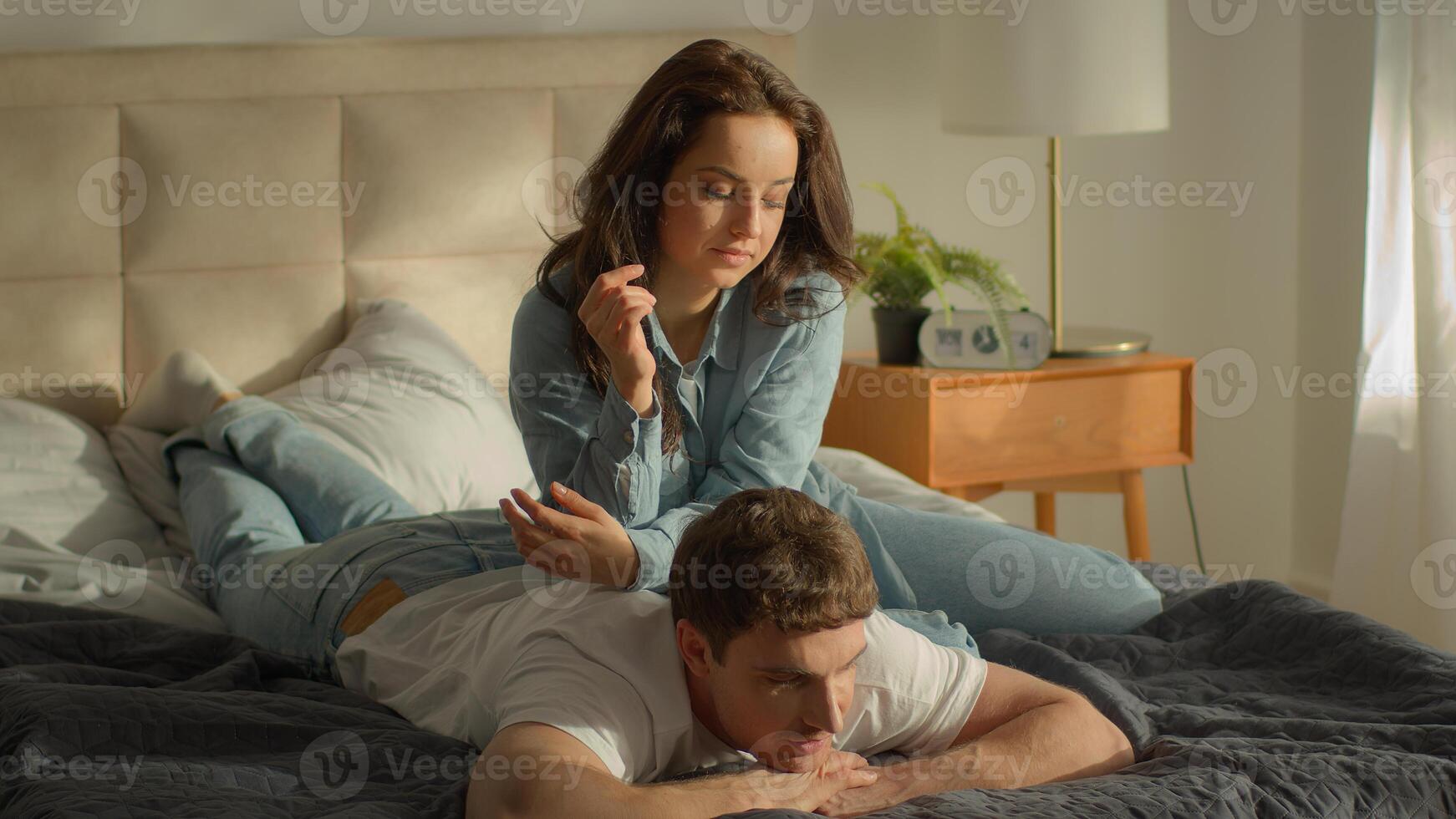 Couple bedroom man lying on bed home woman back massaging pain relaxing help care loving boyfriend girlfriend female male talking girl guy wife husband rest affectionate wellbeing body health married photo