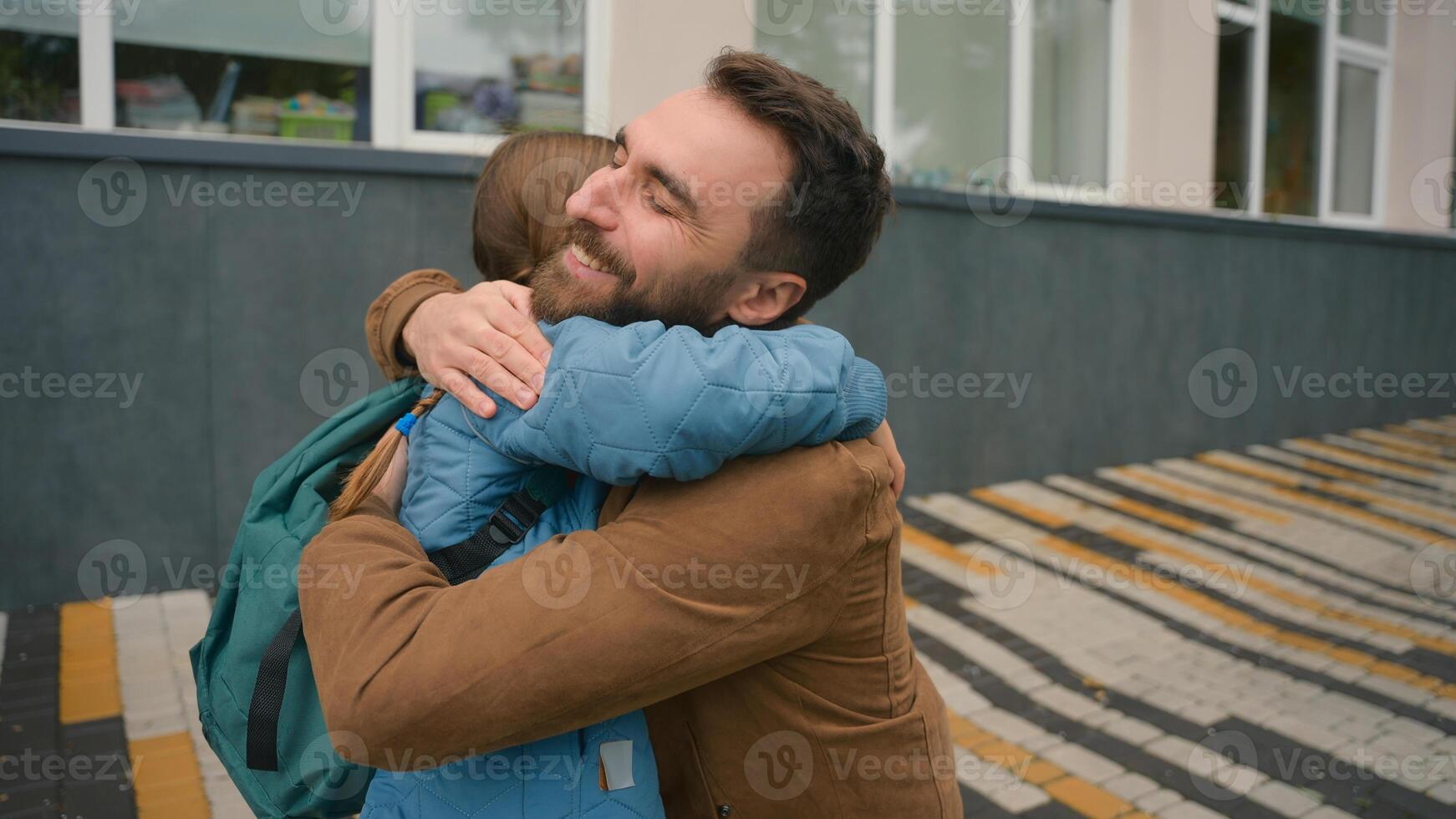 Dad pick up daughter after lessons schoolgirl with backpack elementary school parenting child care happy family man girl laugh smiling enjoy hugging kid education offspring studying meeting embrace photo