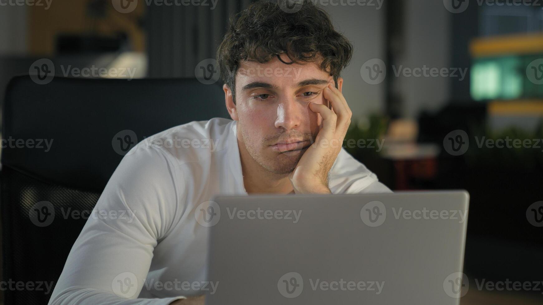 Tired exhausted Caucasian businessman bored fatigued male designer with computer project sad overworked overtime working at creative modern office business man employer work laptop boring deadline photo