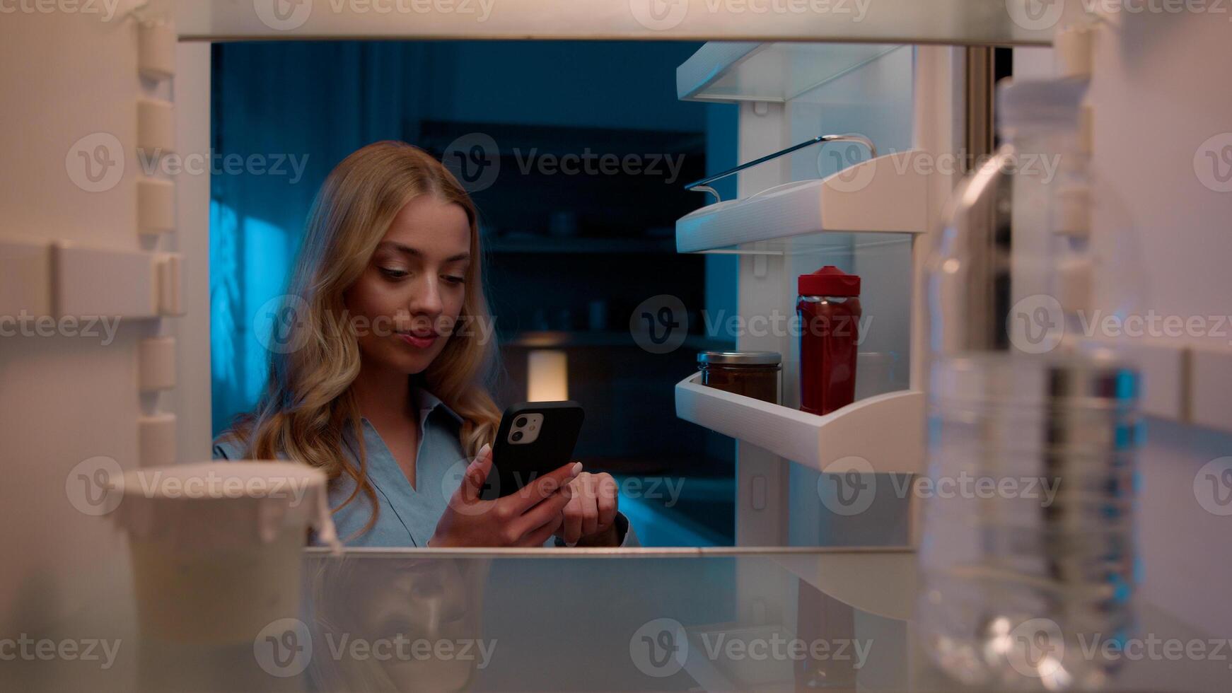 Point of view POV inside refrigerator Caucasian girl hungry woman open fridge at home kitchen look at empty shelves order food products delivery with mobile phone app online service web store shopping photo