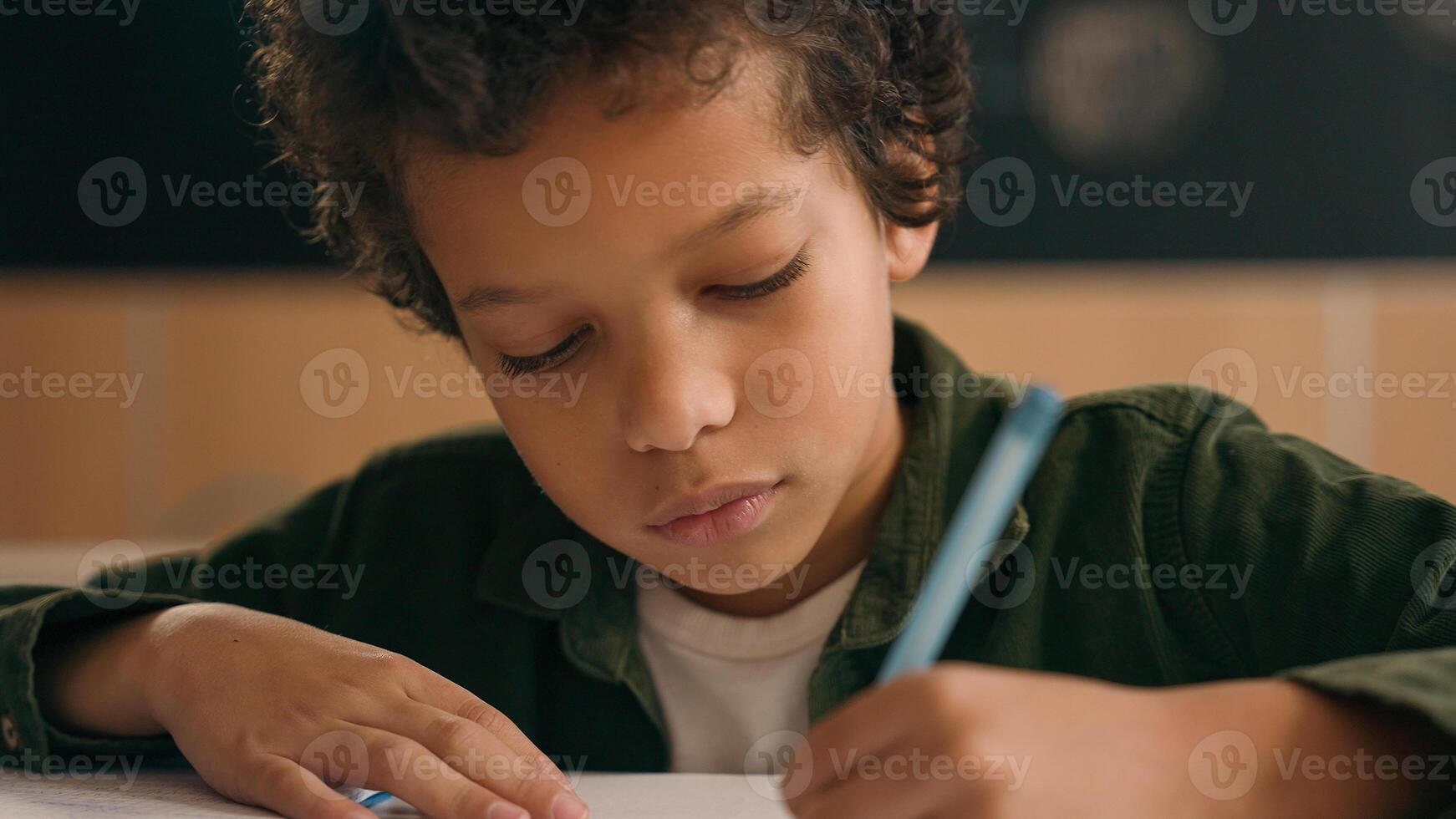 African American school boy son child ethnic guy little kid schoolboy pupil student writing task write copybook study learn elementary primary education studying learning languages math class lesson photo