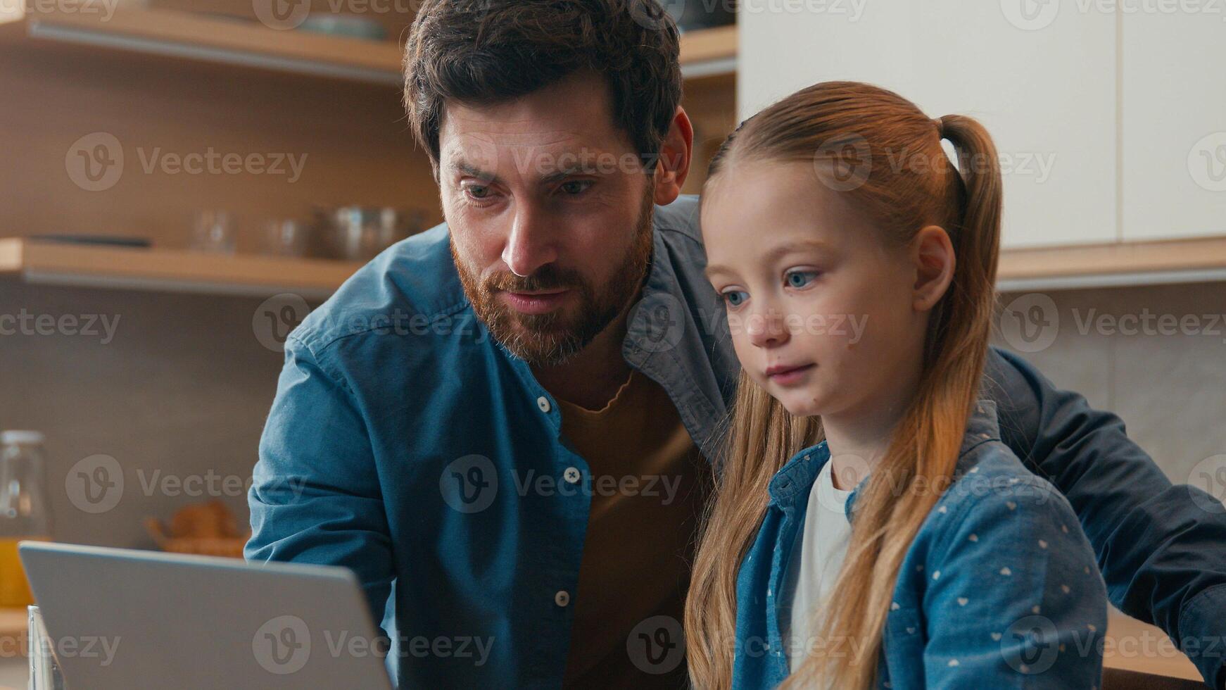 Happy family little daughter kid girl father checking homework helping cute school child with online studies laptop computer using at kitchen parent explaining distance learning at home education app photo