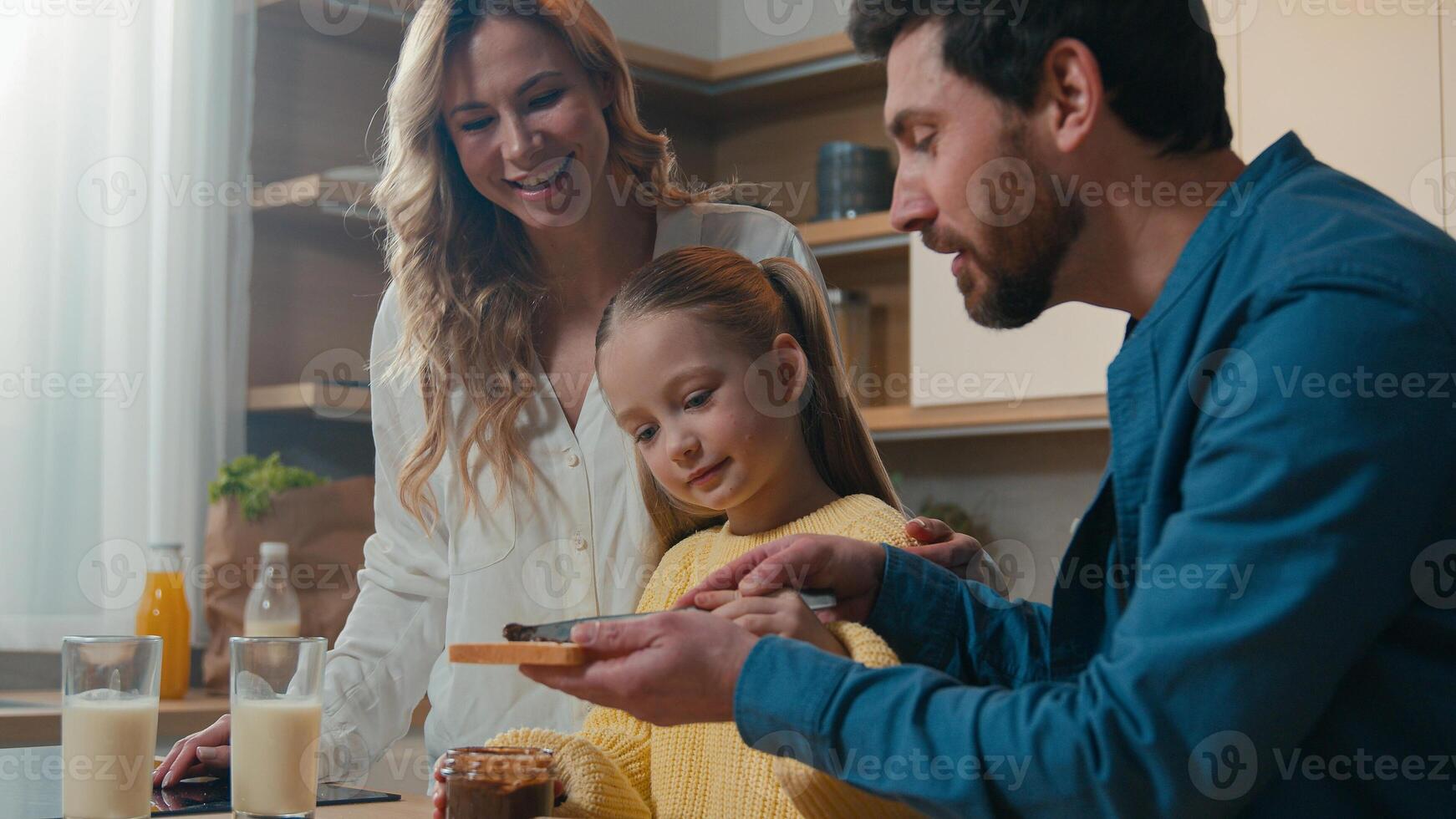 Happy Caucasian family medical insurance loan mortgage credit parents child kid daughter breakfast together at kitchen home food delivery healthy eating chocolate sandwich mother, father little girl photo