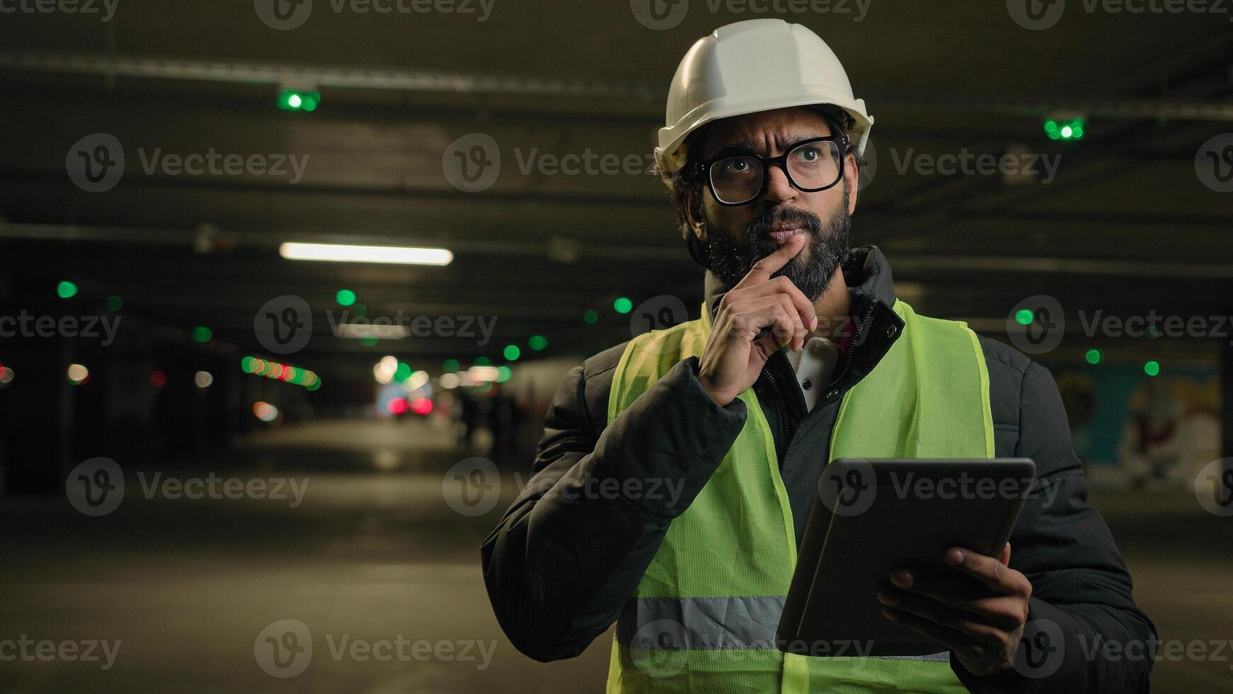 Heavy industry technology engineer Arabian man Indian builder in hard hat electrician architect manufacture worker think pensive ponder problem solution use digital tablet check cyber security system photo