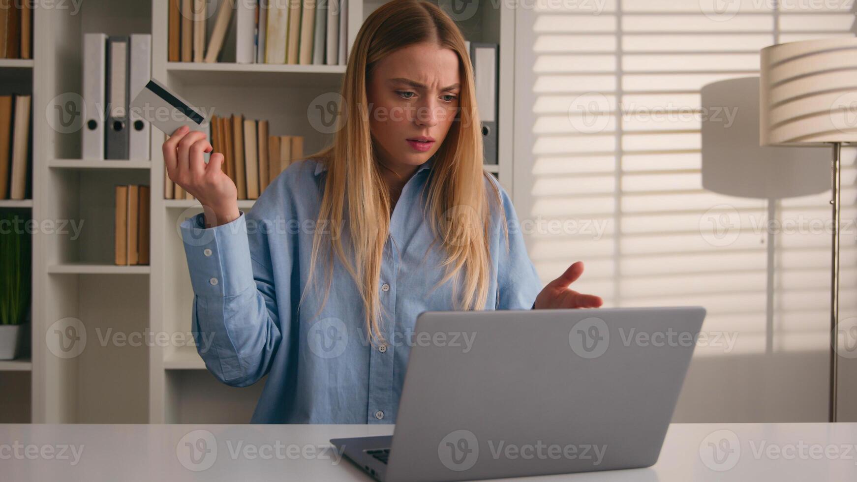 Confused puzzled client female hold bank credit card try to pay online annoyed with payment rejection problem wrong password. Worried girl woman trouble virtual money unsuccessful shopping with laptop photo