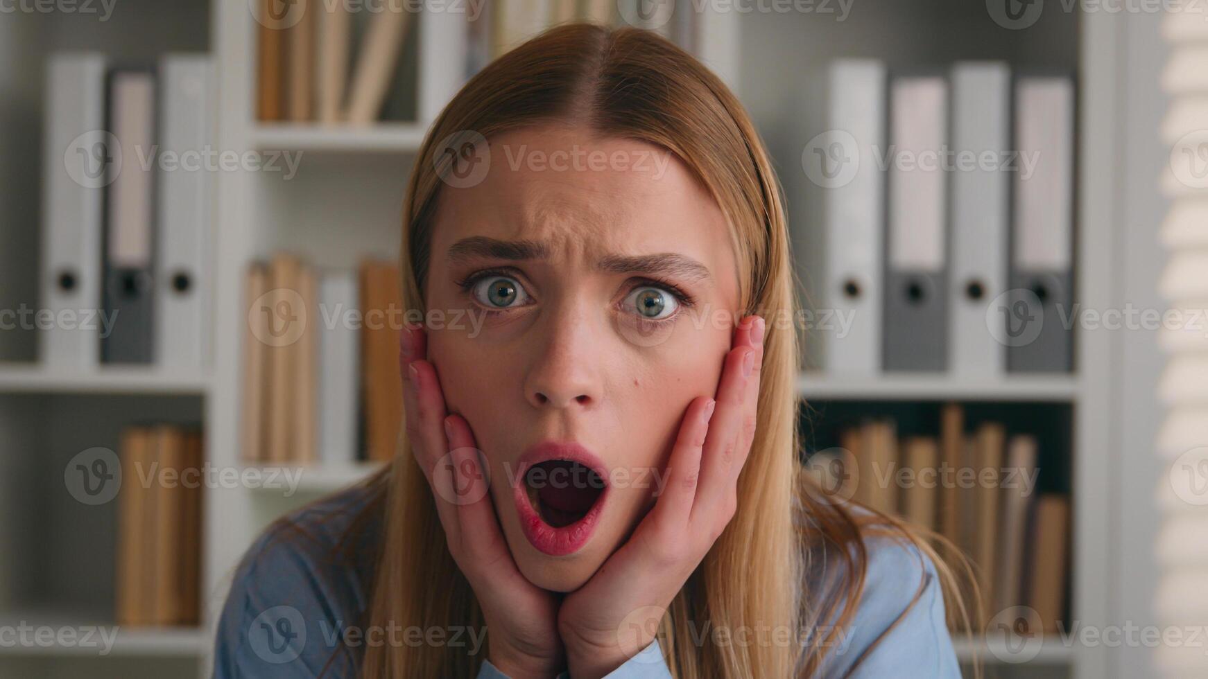 Close up shocked female face Portrait amazed scared afraid astonish Caucasian woman open mouth holding head with shock bad news unexpected business trouble failure problem girl businesswoman in office photo