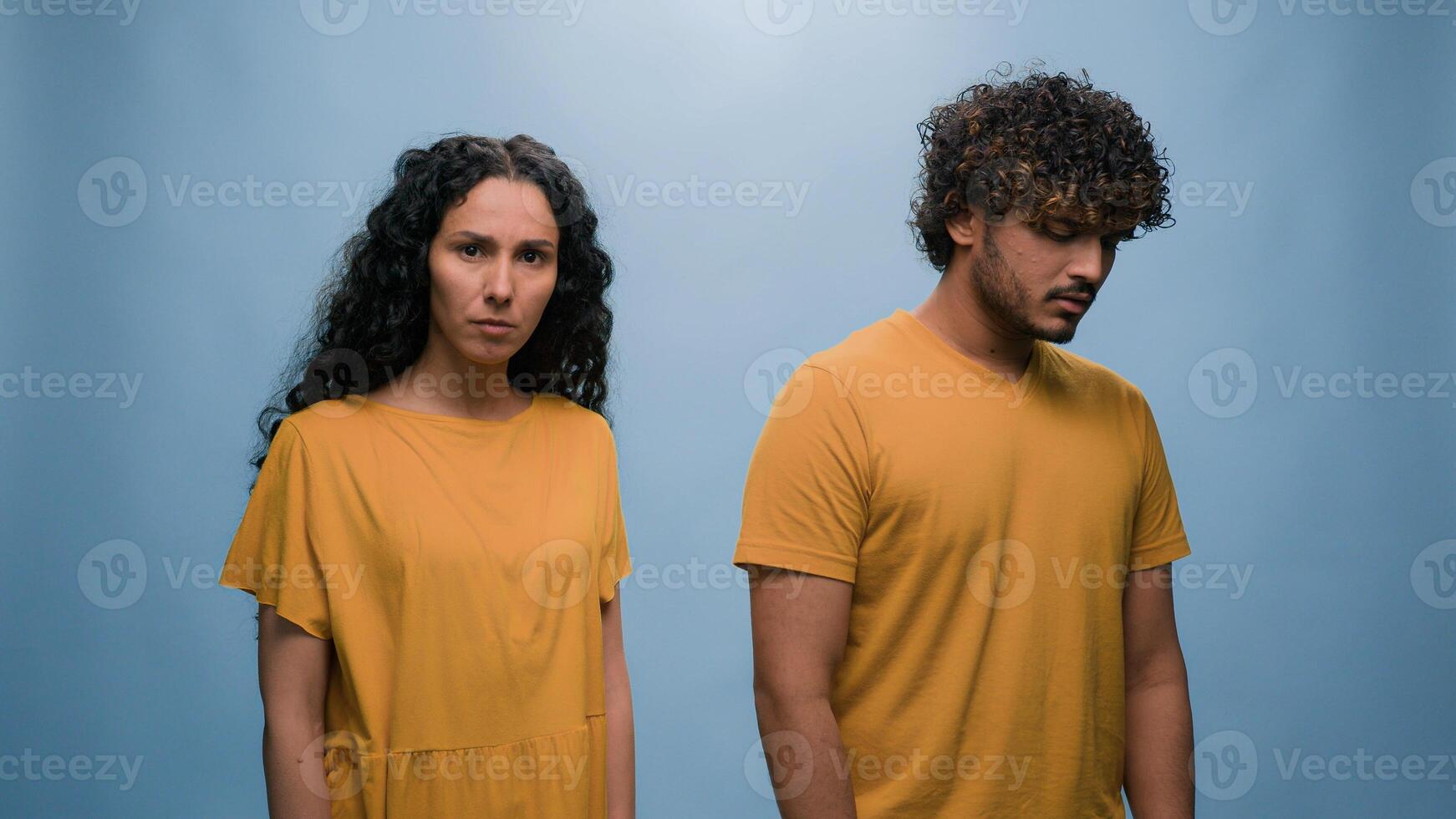 Multiracial couple diverse friends Indian man Hispanic woman quarrel argue angry conflict misunderstanding problem family trouble mad bad relationship blah-blah gesture girl in blue studio background photo