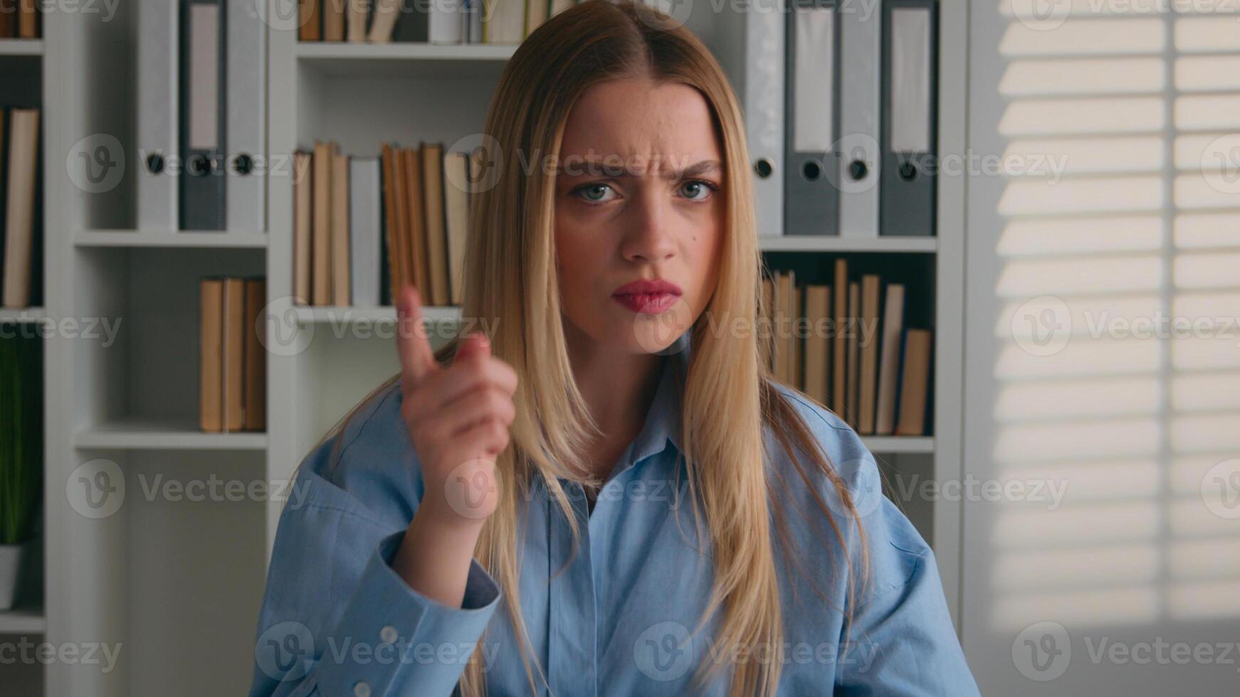 Caucasian angry woman waving index finger treating rejection no never not deny gesture. Businesswoman at office table negative warning student girl at home library dissatisfied forbid condemning scold photo