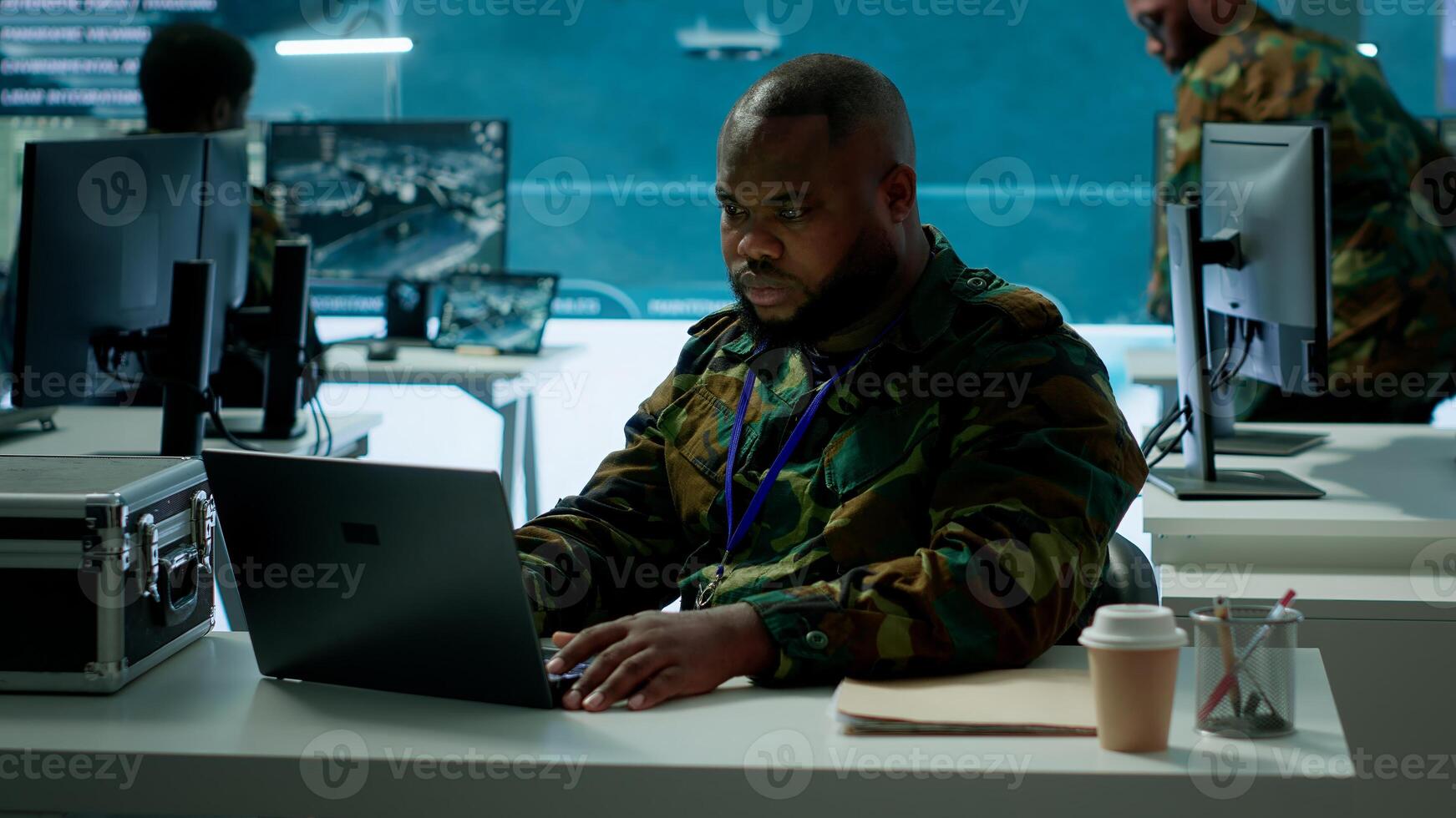Intelligence agents in modern operations center managing surveillance activity and synchronizing security protocols. Army base staff interpret real time data to protect national interests. Camera A. photo