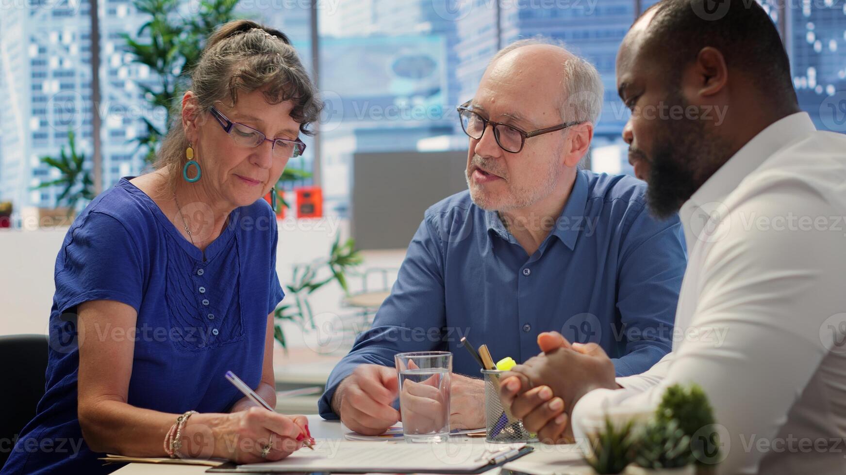 Middle aged couple exploring life insurance contract terms with financial adviser expert, reading pension option and planning an investment for retirement. Professional advice. Camera A. photo