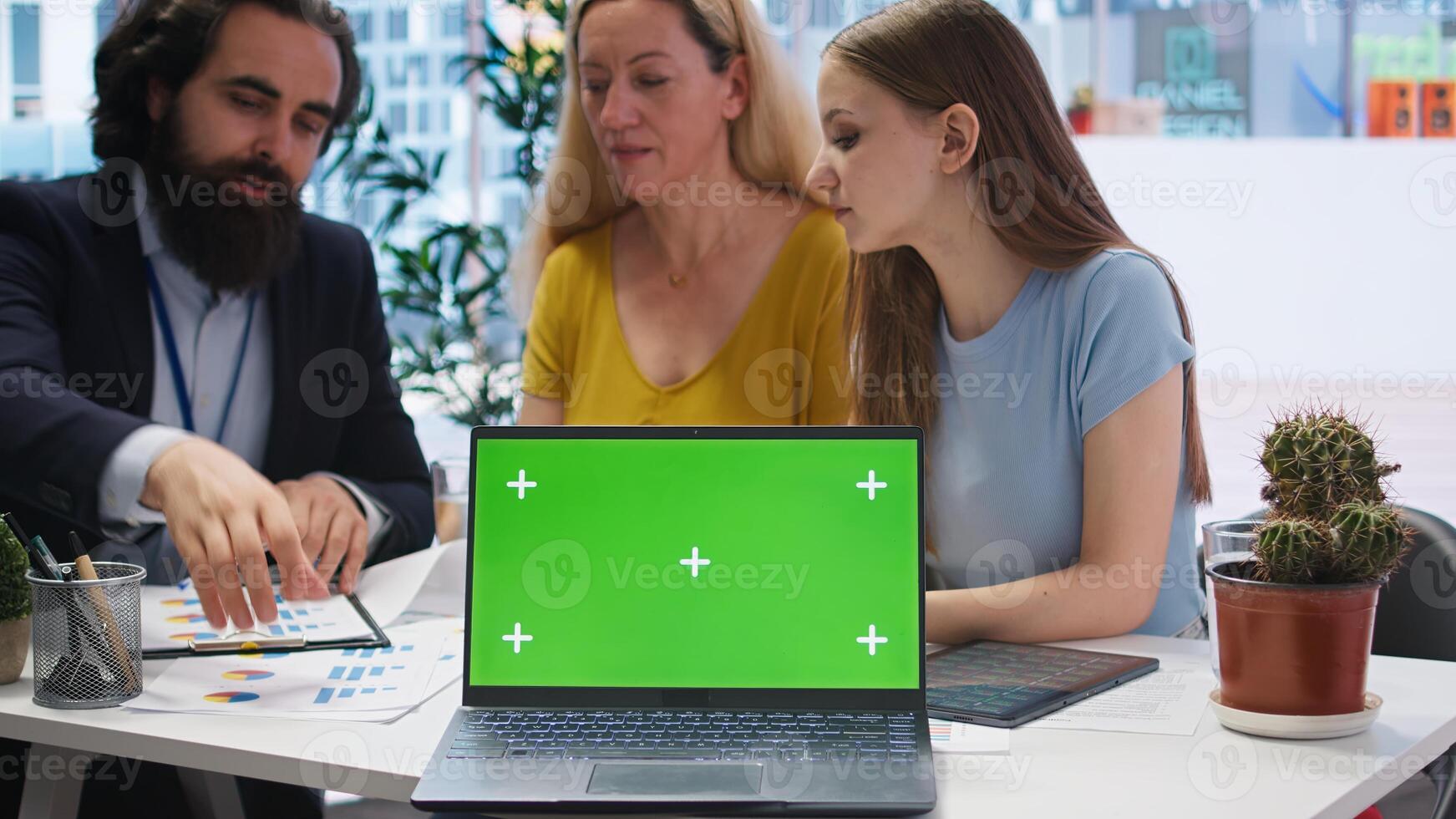 Financial advisor showing data graphs on green screen notebook to customers, analyzing market trends to do forecasting. Clients checking investment plan on chroma key laptop, camera A photo