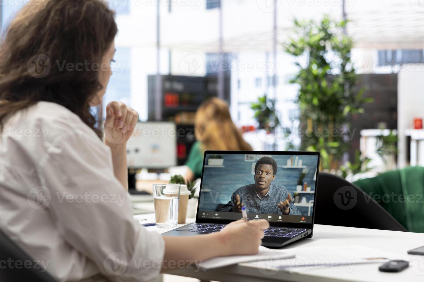 Recruiter hiring for newly opened company position, talking with applicant in remote call about his CV. HR specialist in teleconference meeting on laptop with man, looking over his resume photo