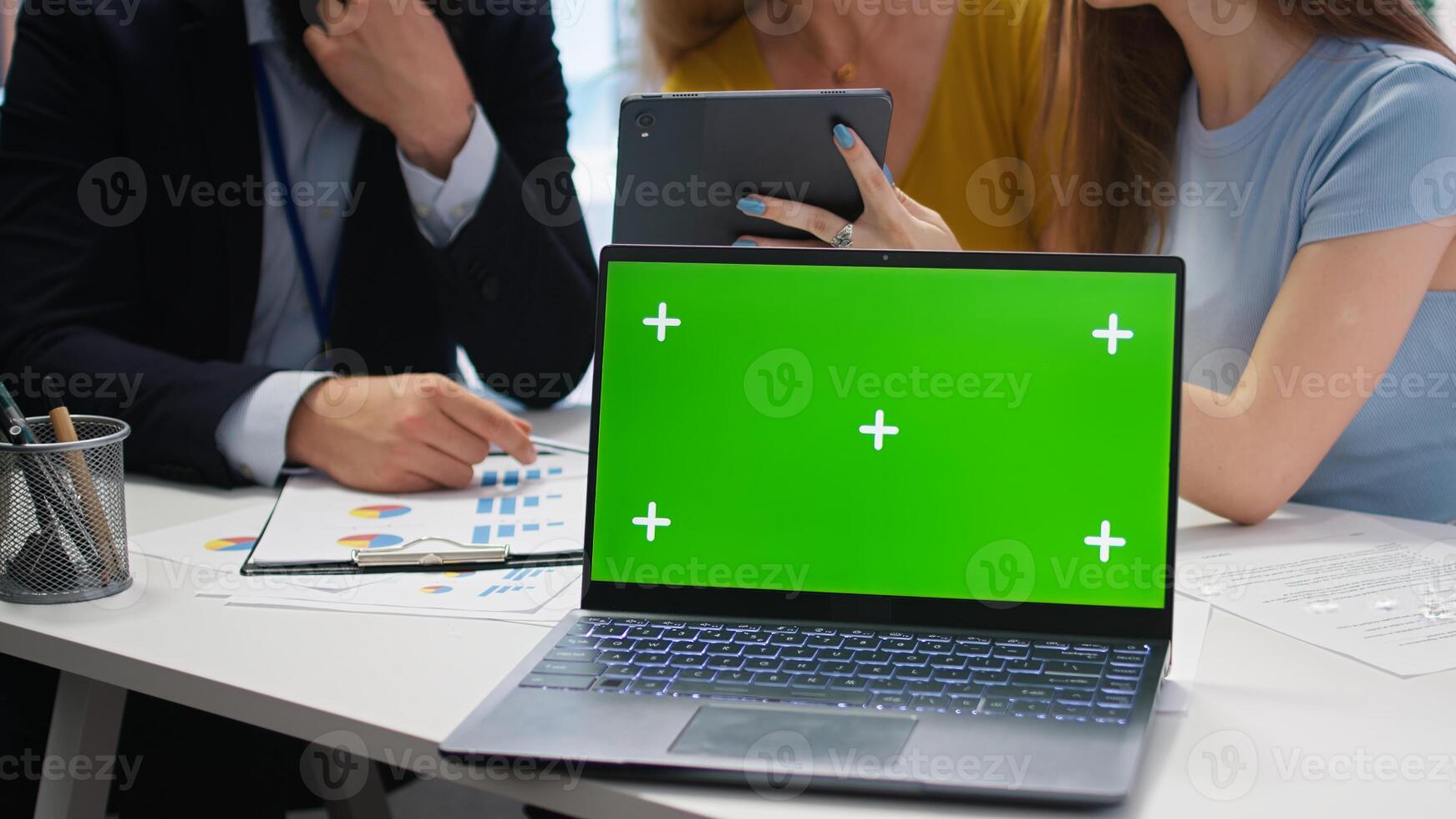 Financial adviser assisting clients in setting up investment accounts with isolated screen laptop, close up. Consultant uses financial planning software on chroma key notebook to help family, camera A photo