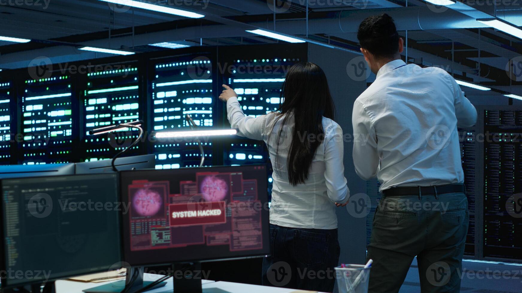 Team of technicians in server hub alerted by hacker passing firewall and stealing sensitive data. Coworkers panicking after seeing security breach notification on PC in data center workspace, camera A photo