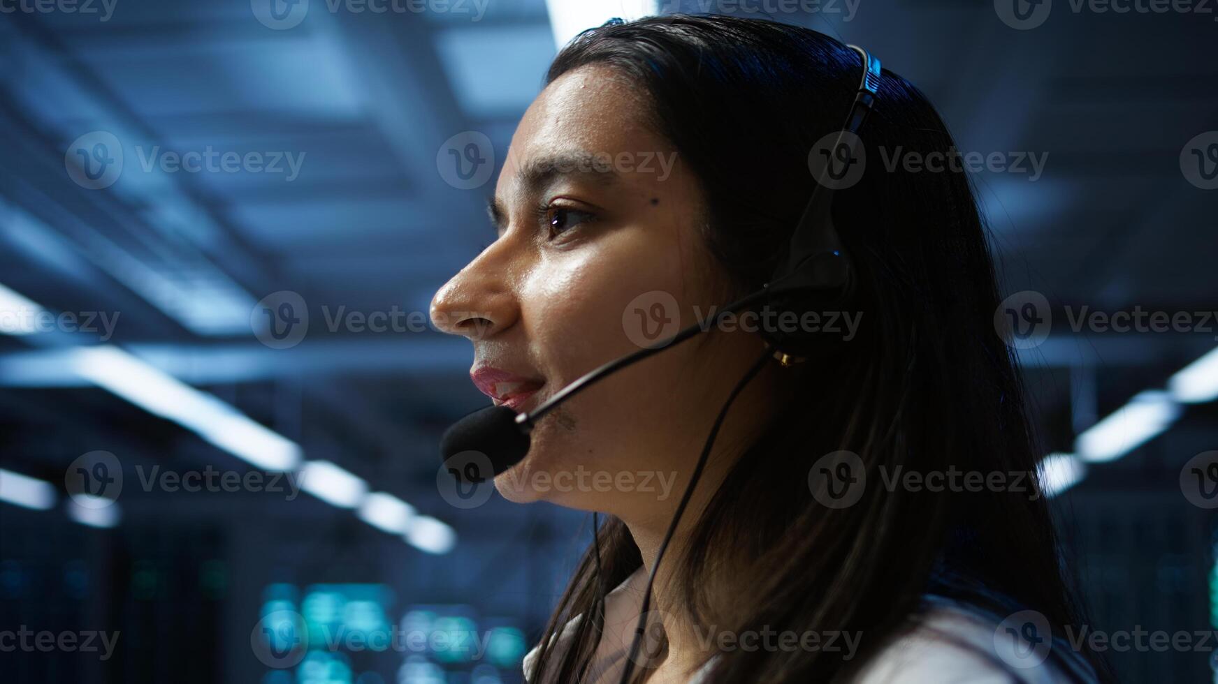 IT expert in data center provides technical support to customers, troubleshooting issues, close up. Server room employee carrying out operational technical interventions requested by clients, camera B photo