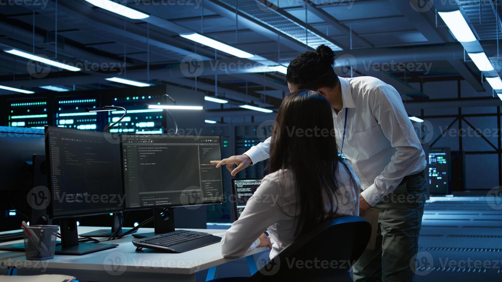 Computer scientists in data center managing and maintaining databases, ensuring data integrity and security. IT staff members updating server room systems using, camera B photo