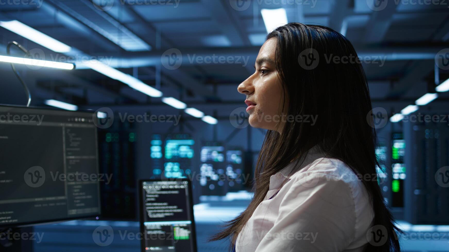 Computer scientist in data center installing software on computer, troubleshooting issues, handheld camera shot. Close up of IT expert in server hub establishing performance benchmarks, camera B photo