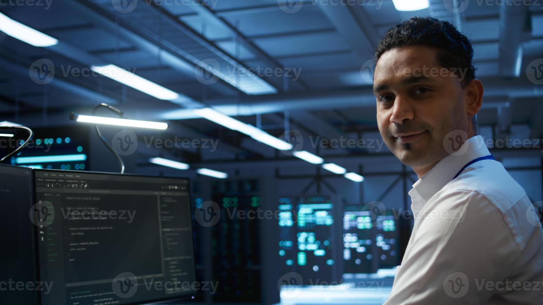 Portrait of smiling data center technician responsible for installation and repair of networking equipment solving tasks. Jolly IT expert doing maintenance on server room infrastructure, camera B photo