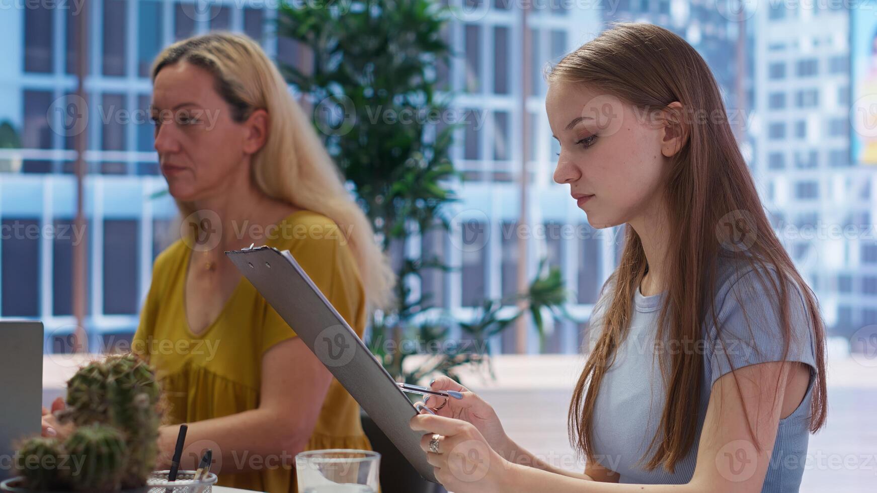 Gen Z young adult looking over personalized planning guide written by financial advisor during meeting. Consultant optimizing living expenses of teenager requesting help, camera B photo