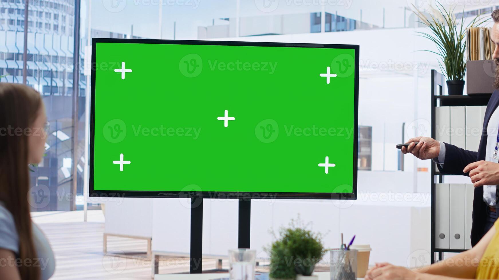 Financial adviser presents market analytics on green screen display to clients, teaching them how to build portfolio. Broker showing stock exchange charts on mockup device to family, camera B photo