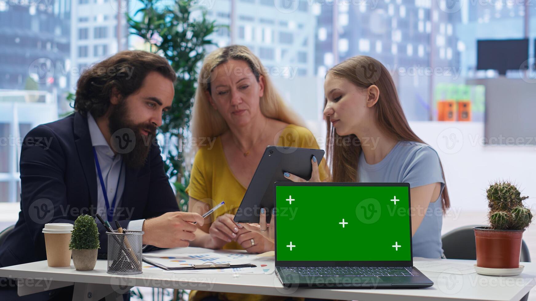 Financial adviser assisting clients in setting up investment accounts with isolated screen laptop, close up. Consultant uses financial planning software on chroma key notebook to help family, camera B photo