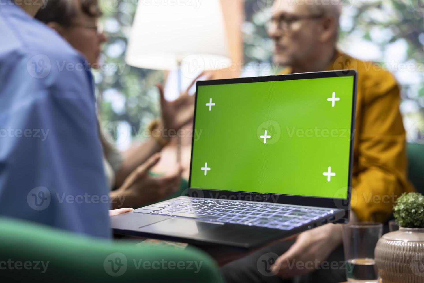 Medical assistant visiting elderly couple for checkup at their home, using isolated display and doing a consultation to give treatment and vitamins for recovery. Nurse talking to senior patients. photo