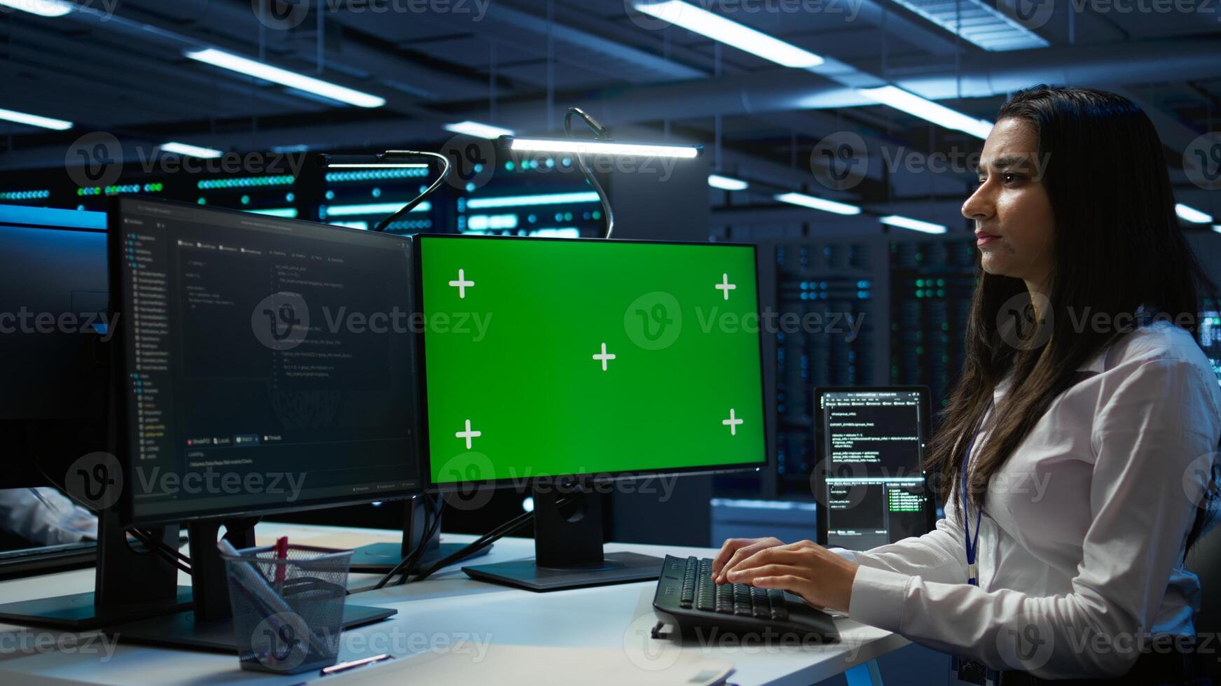 Admin in data center using mockup PC to design, implement and manage gear, ensuring optimal performance and reliability. Expert in server room coding on green screen computer, camera B photo