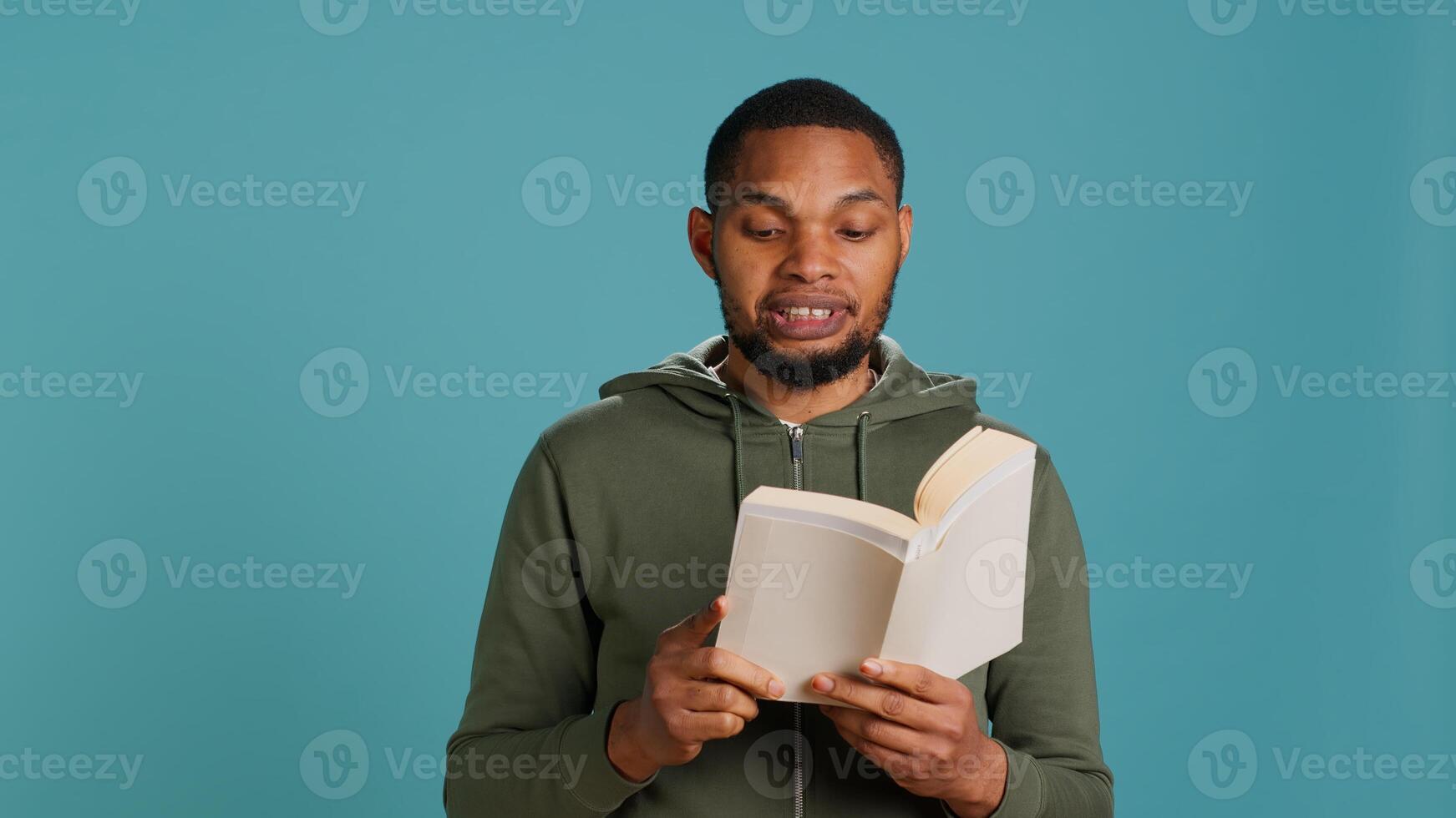 Man reading book aloud, narrating story for audience. Person enjoying literature novel, reciting from pages, entertaining spectators, isolated over studio background, camera A photo