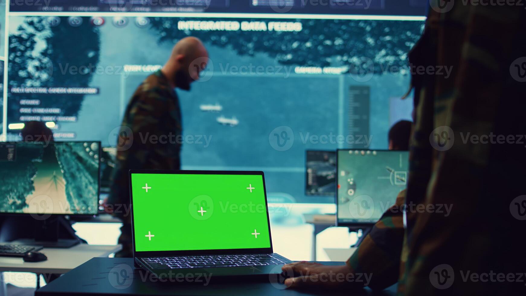 Commander examines a greenscreen on laptop in military command center, reconnaissance army division. Operator gathering intelligence from the field, transmitting real time data. Camera B. photo