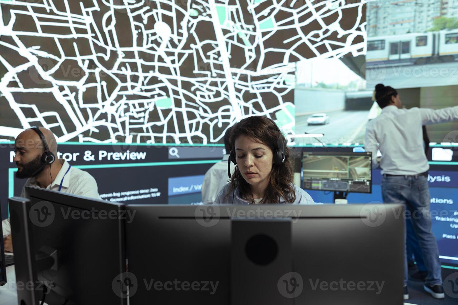 Call center operator transmitting parcel gps coordinates to customers, handling any order delay complains in agency control center. Employee monitoring truck drivers stuck in traffic, CCTV system. photo