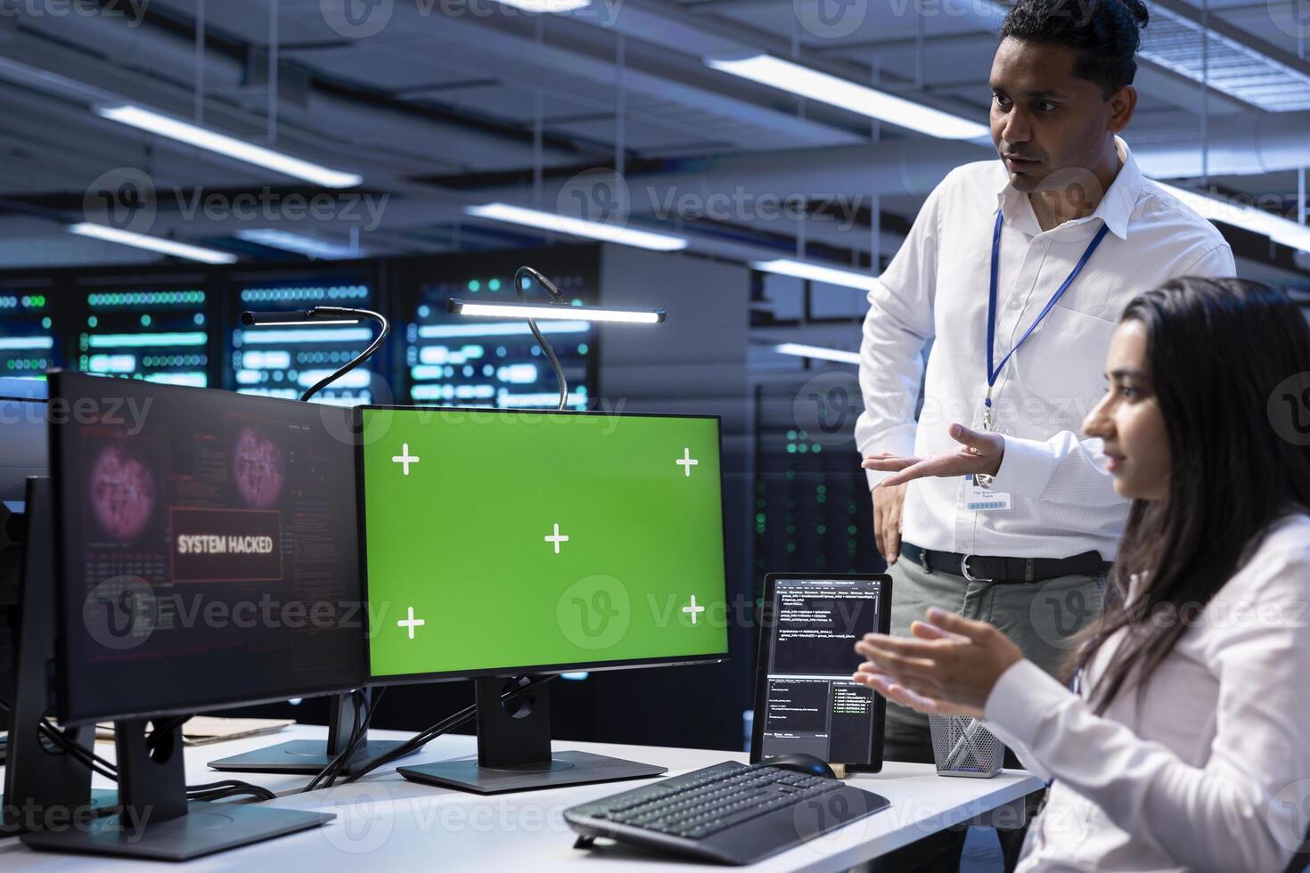 Programmers doing teamwork in server hub trying to protect hardware from hacker using green screen PC. Colleagues in data center workspace trying to fix security breach alert on chroma key computer photo