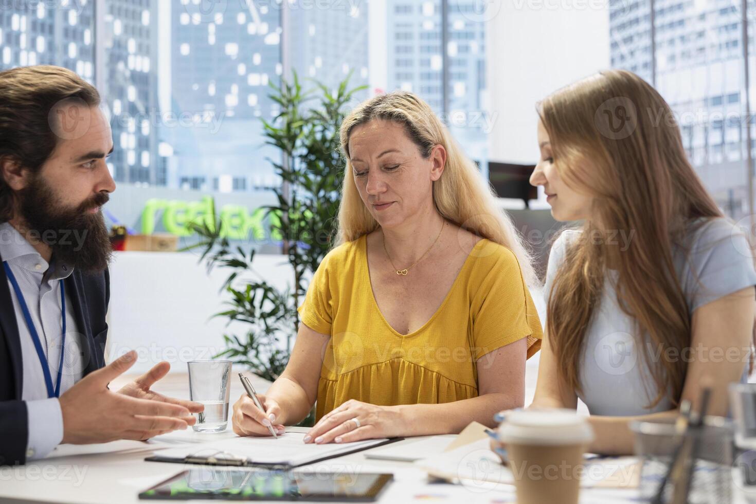 Financial advisor monitoring clients portfolio, offering trade ideas and educating them on topics like asset allocation and risk management. Agent providing customer consultation in office photo