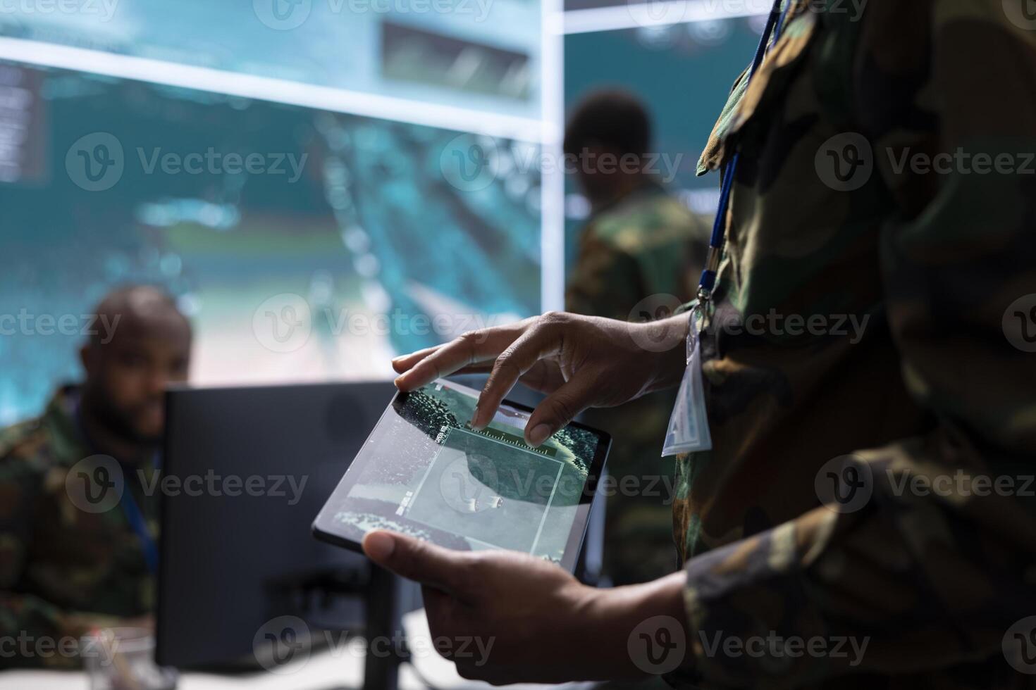 Army intelligence specialists using advanced computer systems and satellite data to enhance national security, critical information. Soldiers planning for a mission in high tech military control room. photo