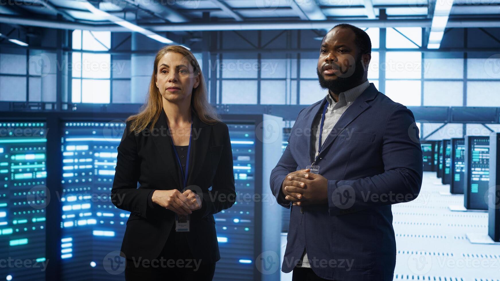 African american expert and coworker looking at holograms in data center, working together. Team members interacting with augmented reality AI visualization in server hub, camera A photo