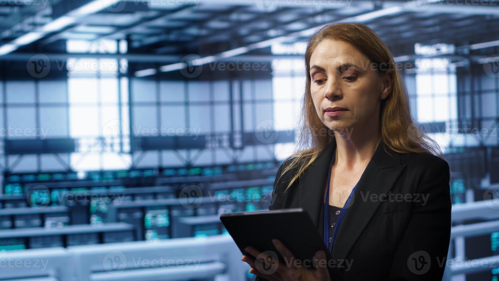 Admin in server room checks recovery plan on tablet, monitoring equipment energy consumption. IT professional uses notebook in data center workplace, ensuring rigs are functioning optimally, camera A photo