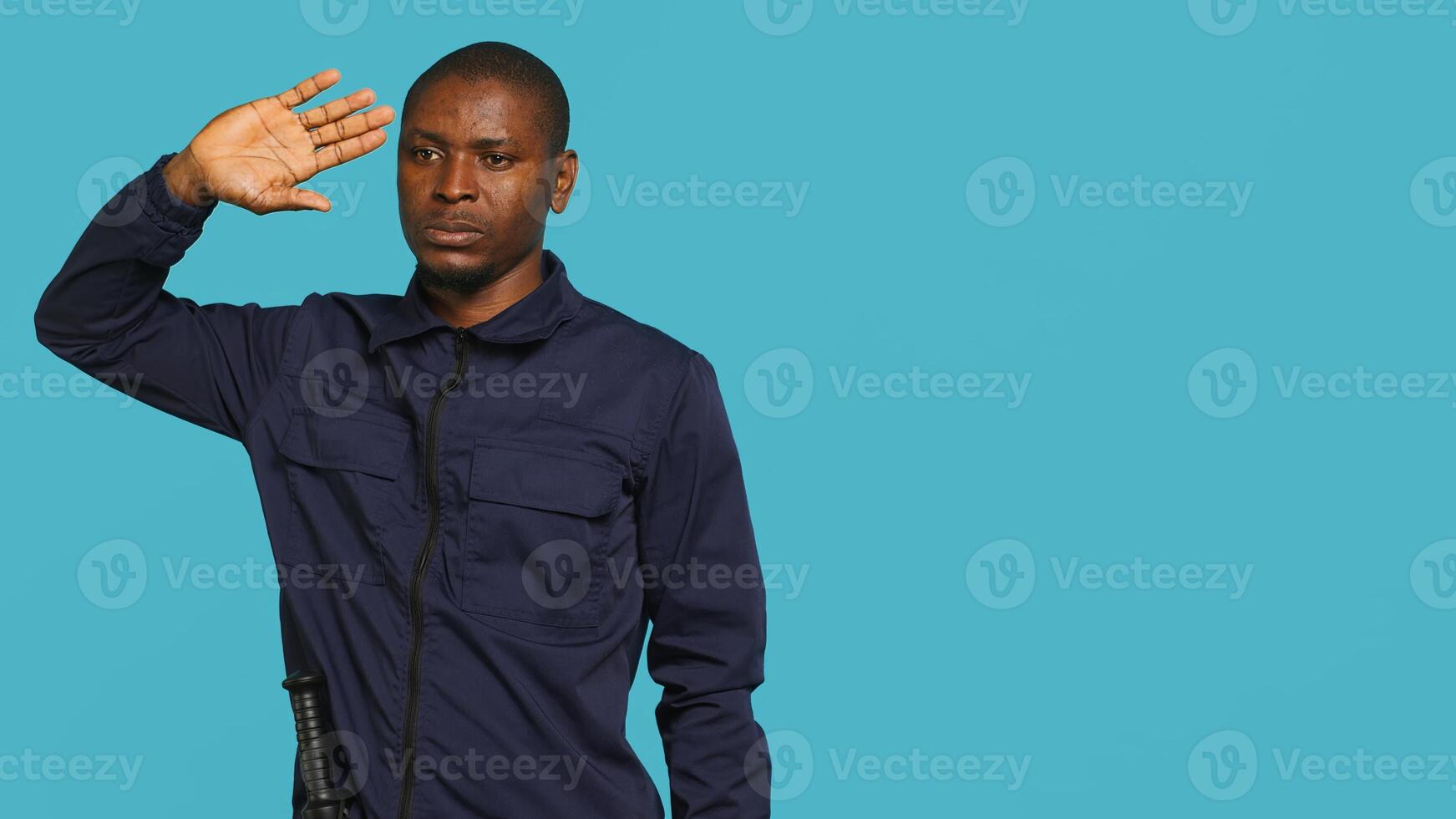 Portrait of security guard scratching head with baton while overseeing premises, thinking. Pensive private law enforcement worker daydreaming, rubbing chin, studio backdrop, camera A photo