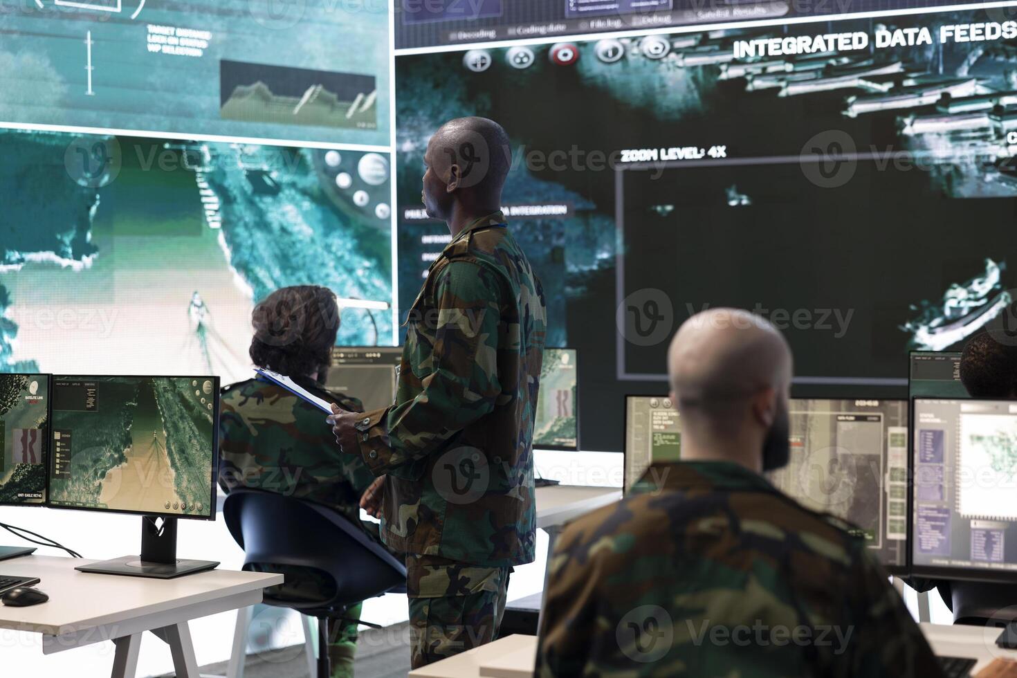 Military personnel undertaking a secret service operation with real time data on a big screen, field troops examining satellite CCTV imagery. Conducting a reconnaissance mission in control center. photo