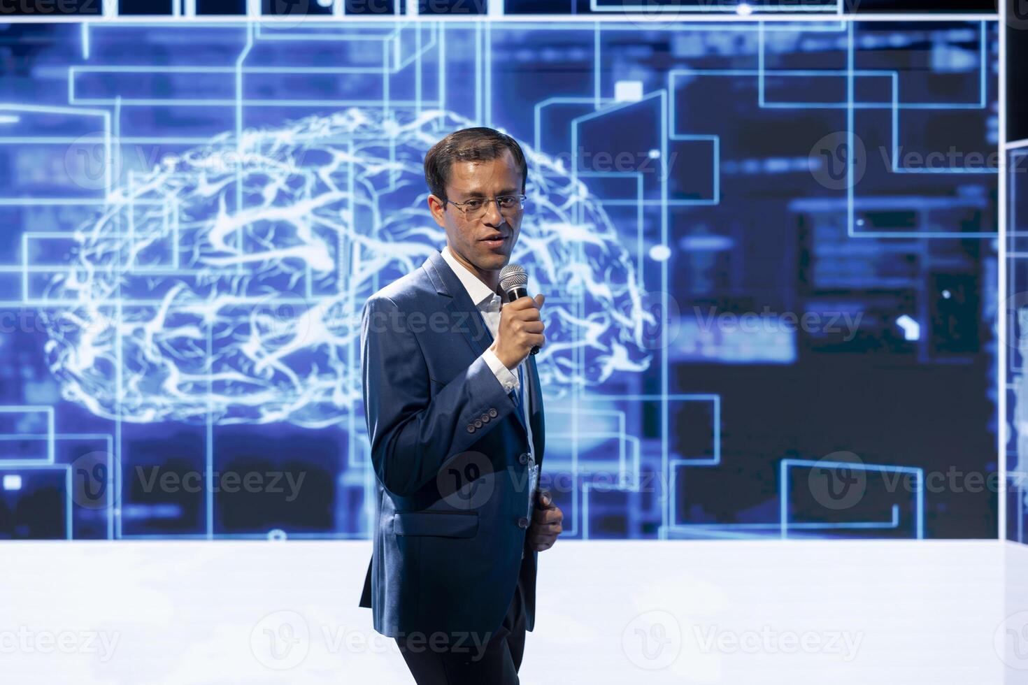 Engaging presenter talking at AI convention using microphone, sharing industry expertise to inspire audience. Professional exploring latest artificial intelligence technologies and tools at tech event photo