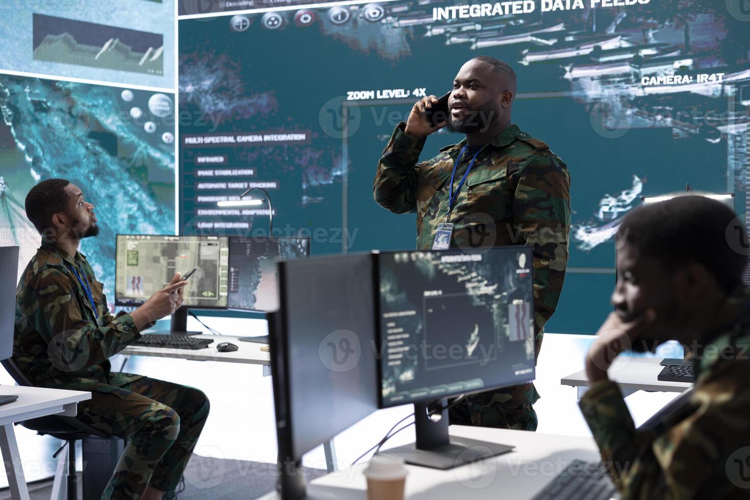 Group of soldiers in a high tech office environment collaborates on intelligence analysis, data processing and strategic planning. Maintaining national security and operational command service. photo